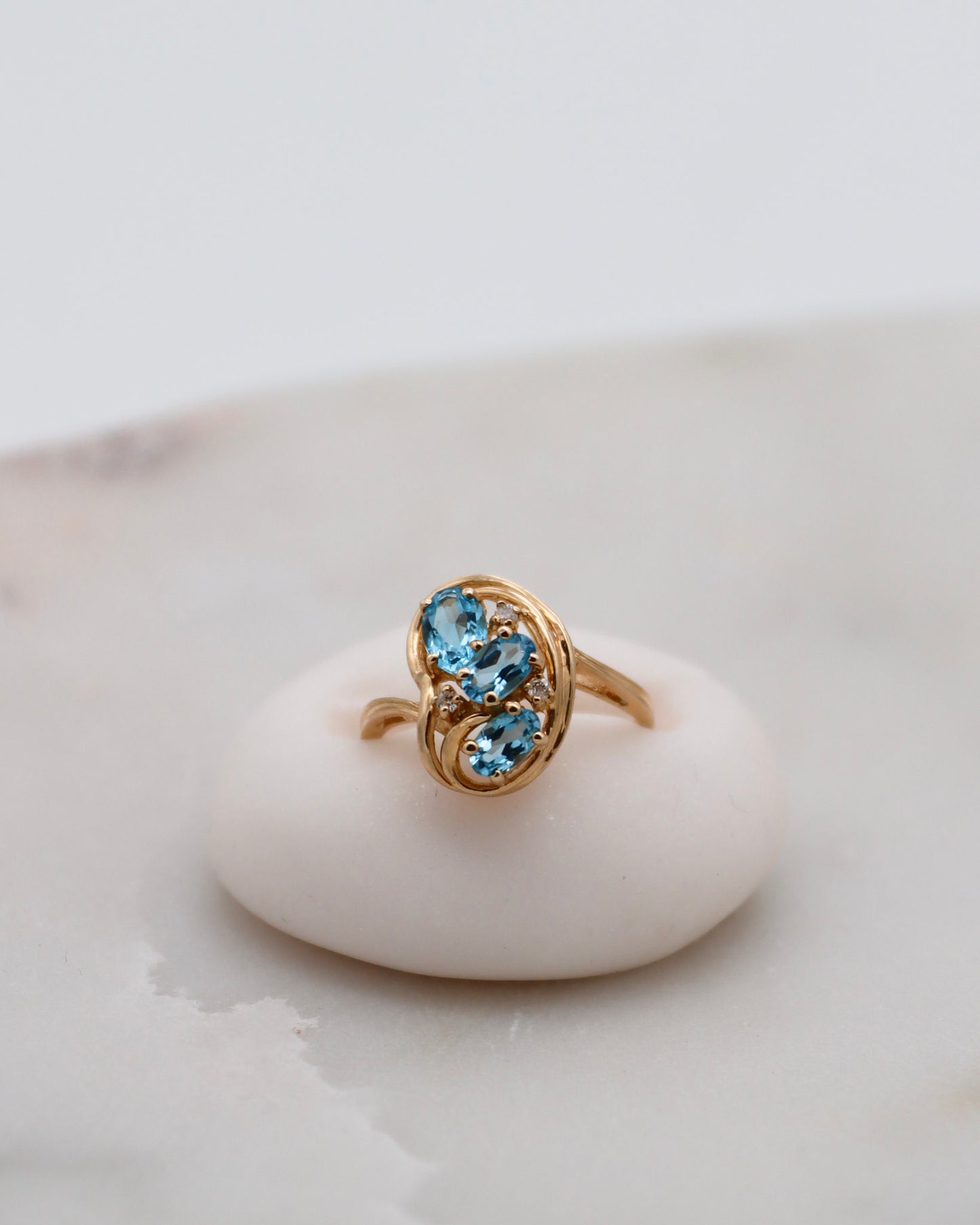 Vintage-Ring Theresa mit 0.60ct blauen Topasen & 0.05ct Brillanten, geschwungene Ringschiene aus 585/-Gelbgold – erhältlich in München und Augsburg