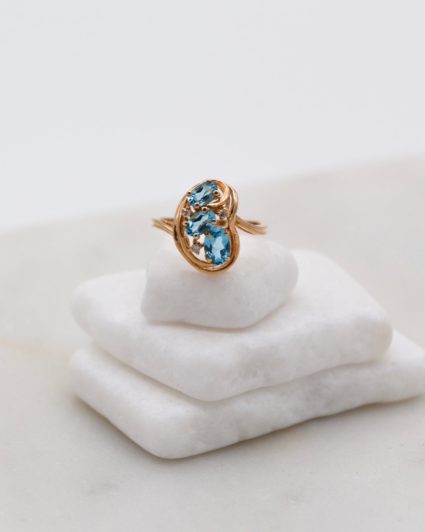Vintage-Ring Theresa mit 0.60ct blauen Topasen & 0.05ct Brillanten, geschwungene Ringschiene aus 585/-Gelbgold – erhältlich in München und Augsburg
