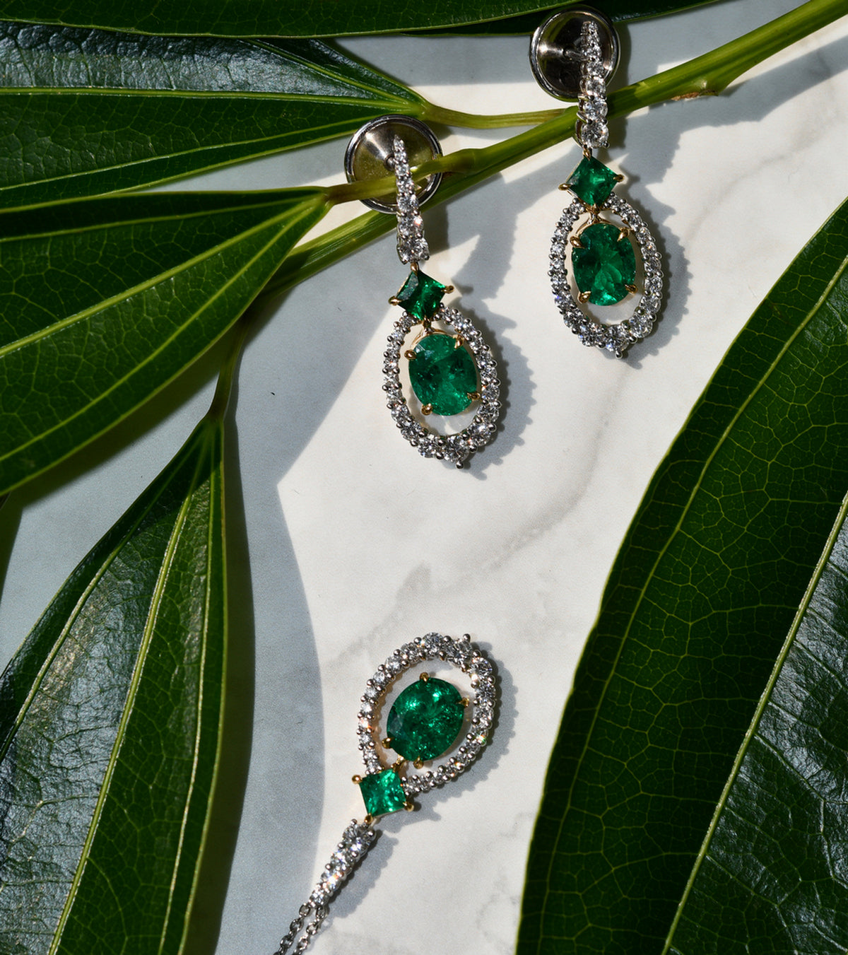 Außergewöhnliche ovale Ohrhänger mit Smaragd- und Diamant-Halo