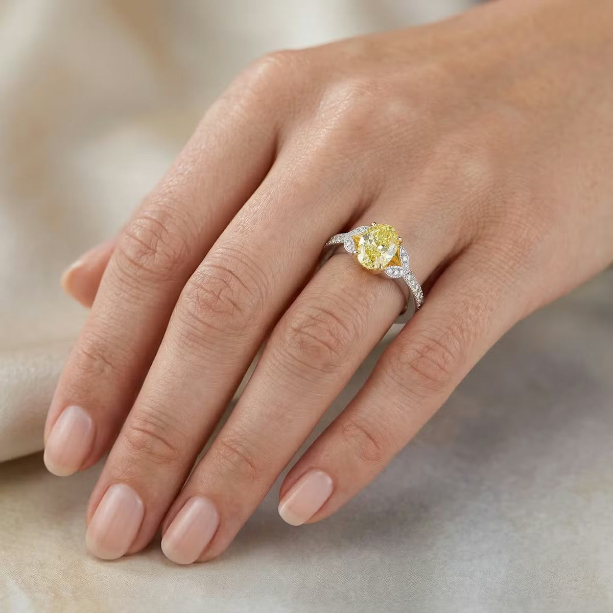 Ring mit gelbem Diamanten im Rundschliff und Pavé-Fassung an den Seiten