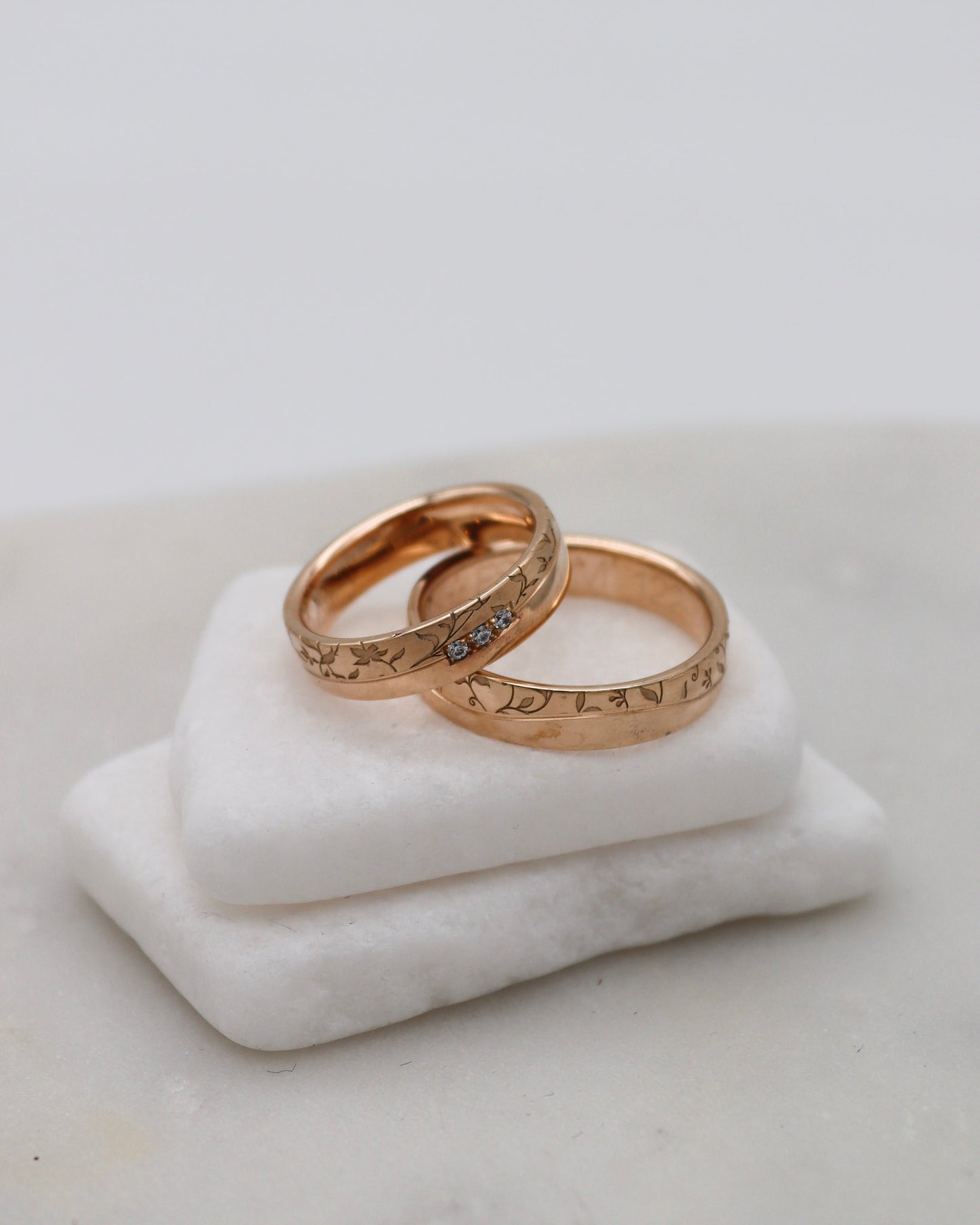 Apricotgoldene Eheringe mit Blumenmuster und 0.045ct Brillanten in eckiger Fassung