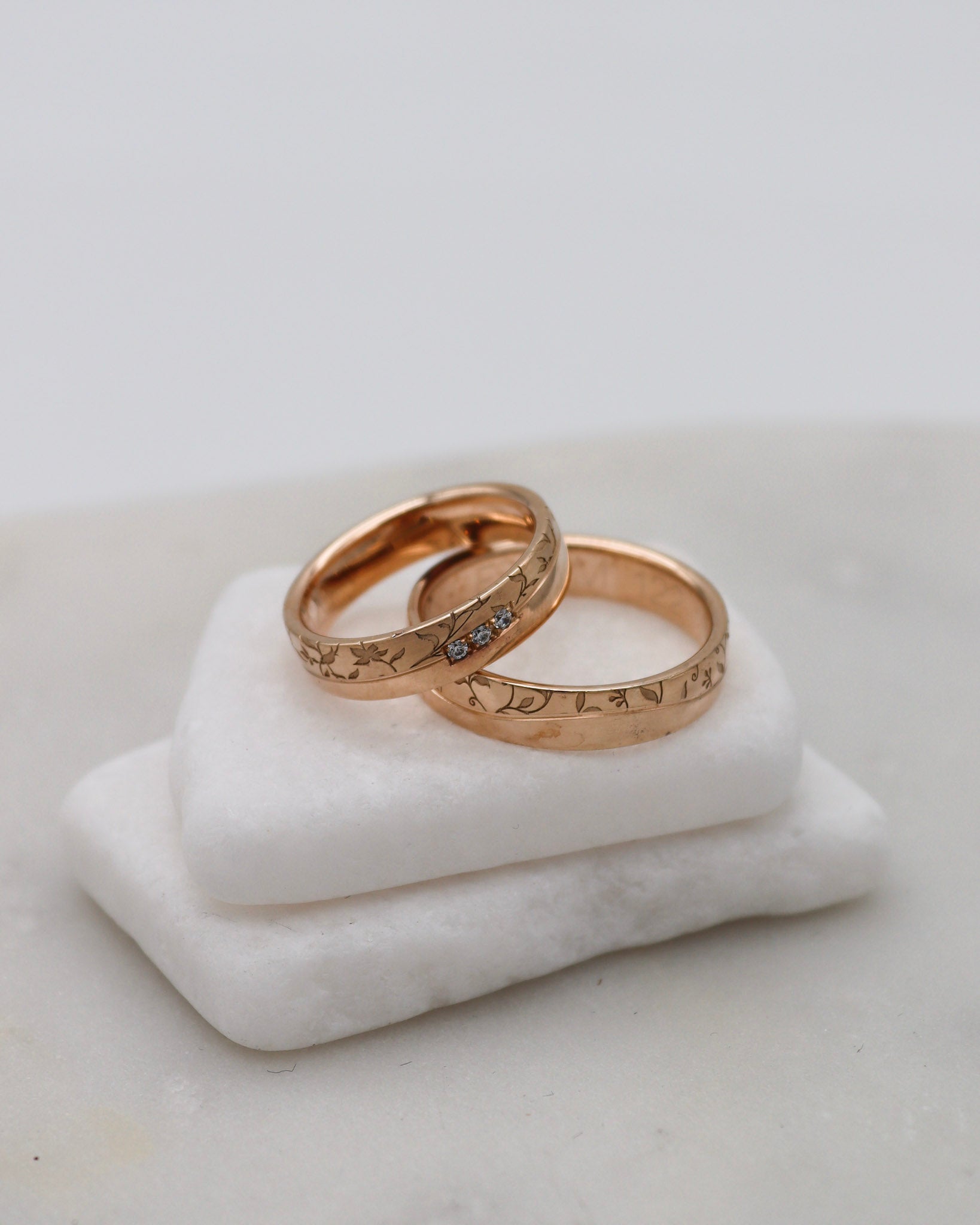 Apricotgoldene Eheringe mit Blumenmuster und 0.045ct Brillanten in eckiger Fassung