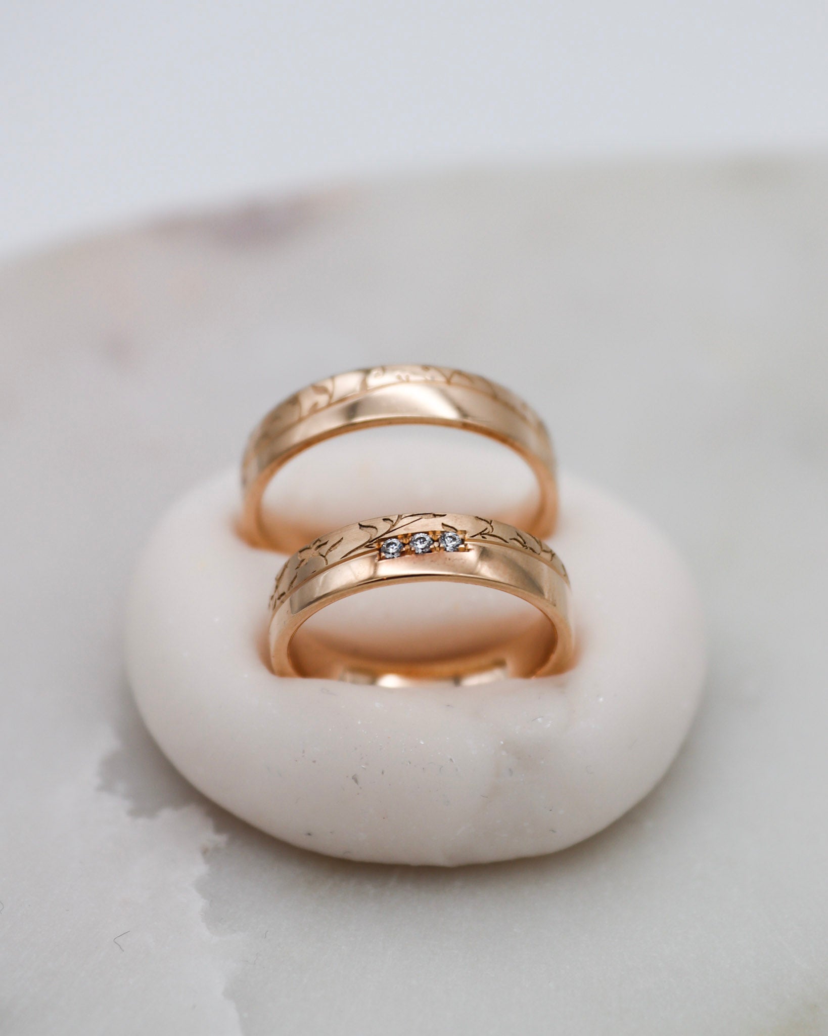 Apricotgoldene Eheringe mit Blumenmuster und 0.045ct Brillanten in eckiger Fassung