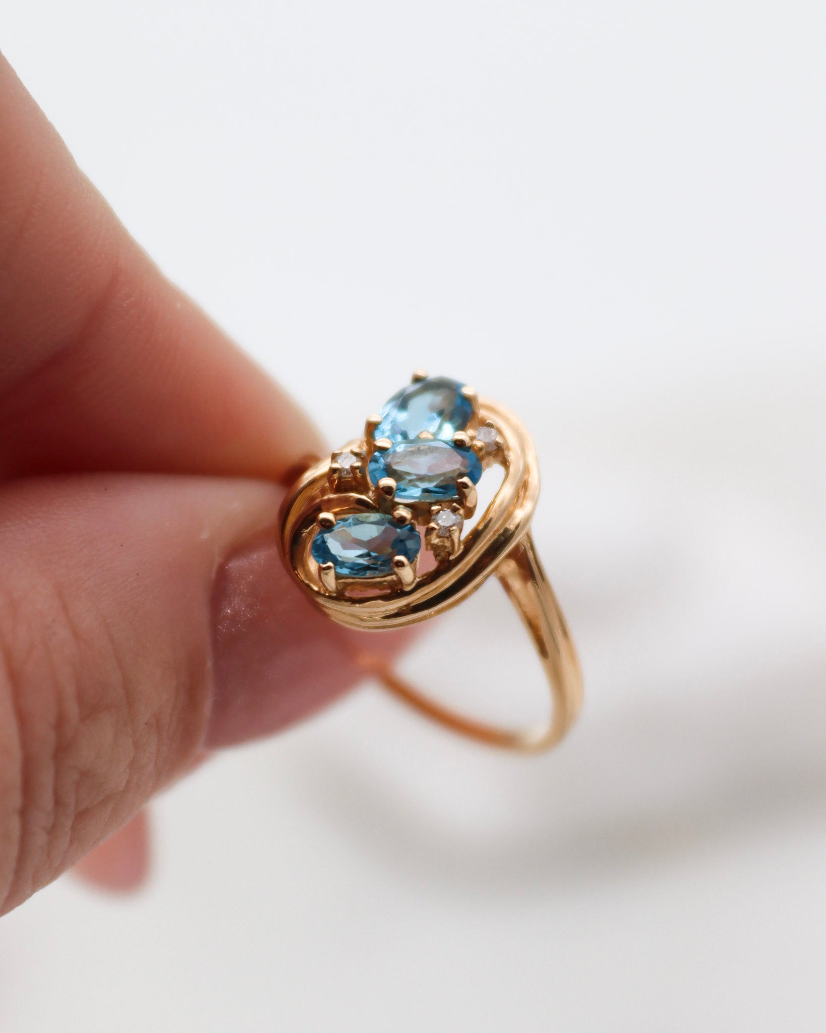 Vintage-Ring Theresa mit 0.60ct blauen Topasen & 0.05ct Brillanten, geschwungene Ringschiene aus 585/-Gelbgold – erhältlich in München und Augsburg