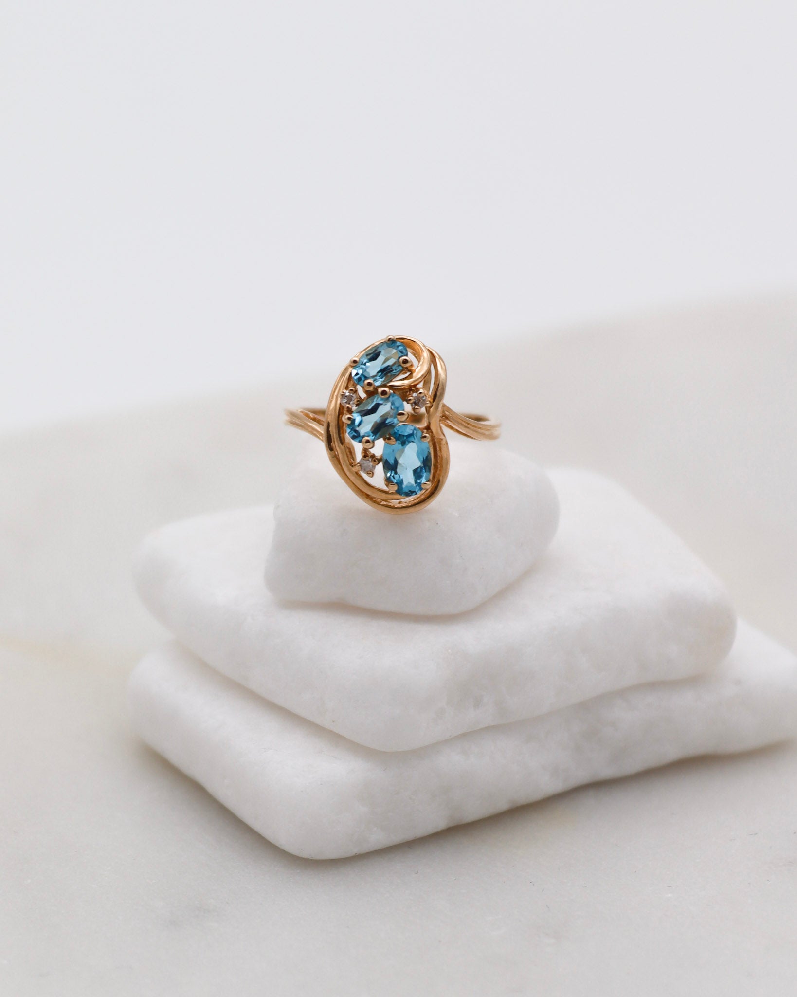 Vintage-Ring Theresa mit 0.60ct blauen Topasen & 0.05ct Brillanten, geschwungene Ringschiene aus 585/-Gelbgold – erhältlich in München und Augsburg