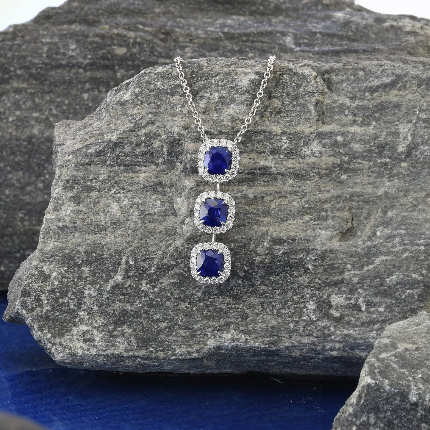 Blauer Saphir im Kissen-Design und Diamant-Anhänger mit drei Steinen und Halo-Fassung